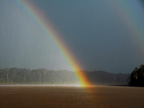 KLIMAAT ECUADOR: REGENSEIZOEN: Regenboog over de Aguarico Rivier.