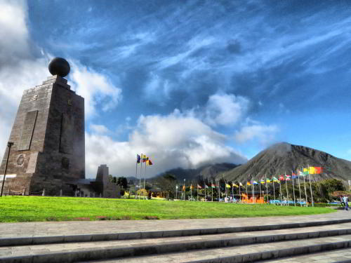 WHAT IS MITAD DEL MUNDO MONUMENT?  monument with flags.